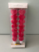 Factory-sealed 2-pack box of At Home Red Heart LED Taper  Candles, showcasing two stacked heart-shaped flameless sticks with included batteries.