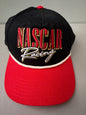 Brand new 2026 NASCAR racing rope trucker hat in black and red, featuring a vibrant embroidered front logo, white braided rope trim, and adjustable snapback closure