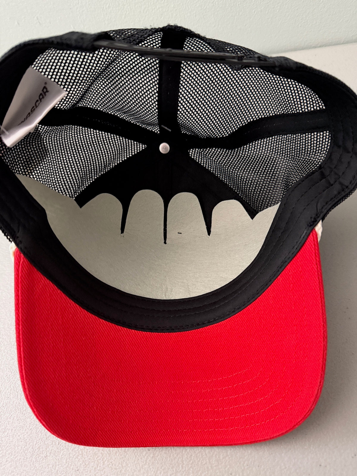 Inside View: Brand new 2026 NASCAR racing rope trucker hat in black and red, featuring a vibrant embroidered front logo, white braided rope trim, and adjustable snapback closure.