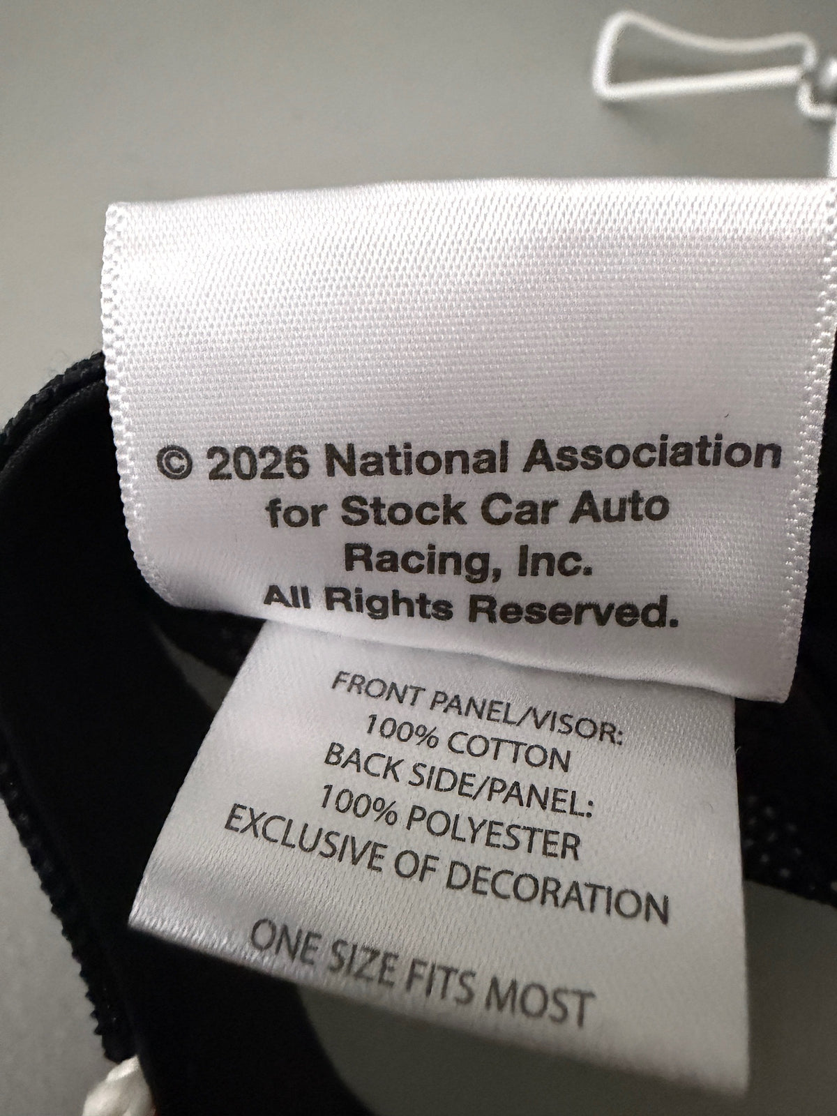 Official Tag View Opposite Side: Brand new 2026 NASCAR racing rope trucker hat in black and red, featuring a vibrant embroidered front logo, white braided rope trim, and adjustable snapback closure