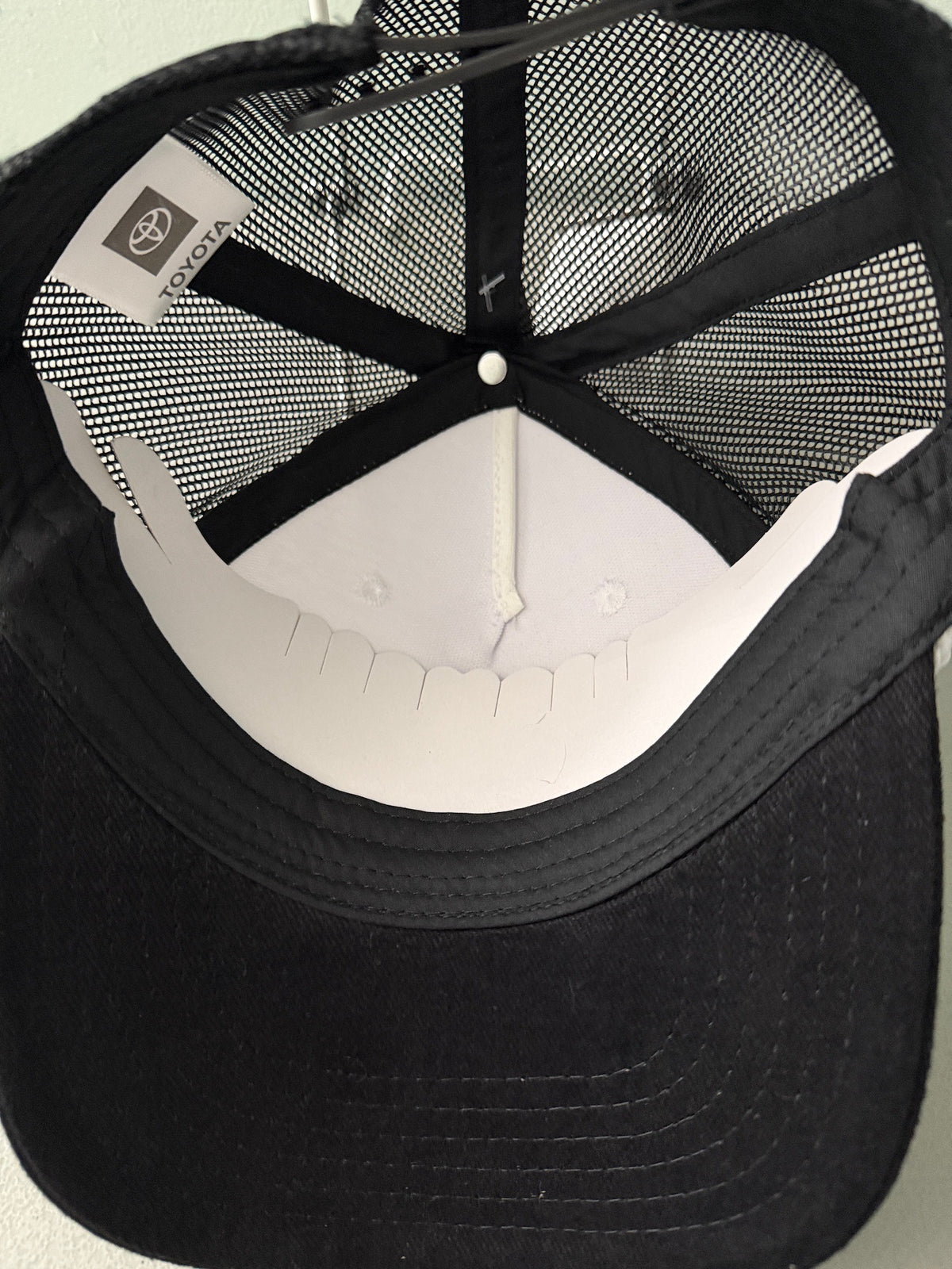 Inside View: Brand new Toyota Off-Road Racing rope trucker hat in black and white, featuring a large embroidered retro shield logo patch, checkerboard racing stripes, and a braided white rope detail on a snapback cap from Bell's Bargain Barn.