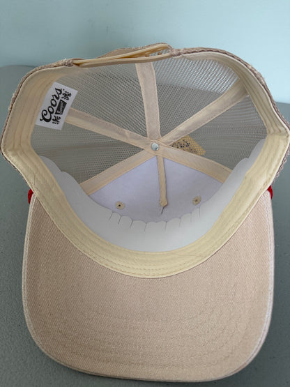 Inside View: Brand new Coors Banquet Beer Fy Fishing mesh trucker hat featuring a cream structured crown, an embroidered oval patch with a rainbow trout graphic, tan mesh panels, a bright red braided front visor rope, and a snapback closure from Bell's Bargain Barn