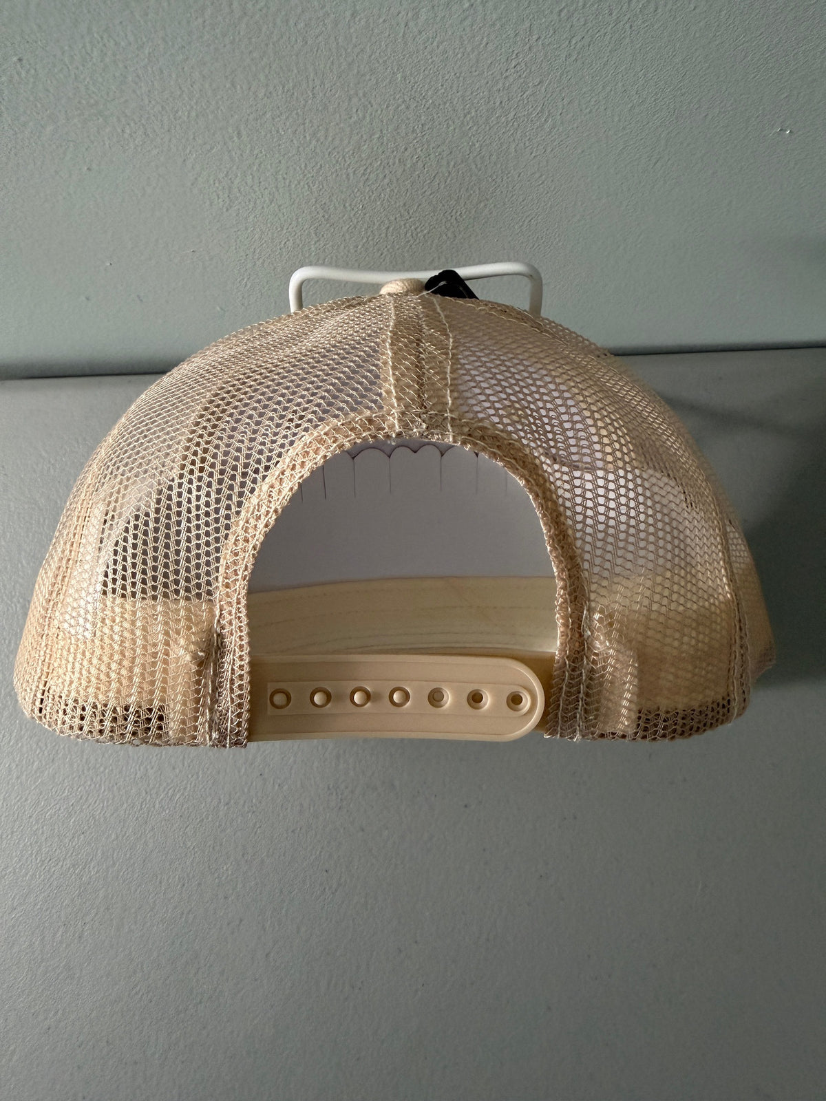 Back View: Brand new Coors Banquet Beer Fy Fishing mesh trucker hat featuring a cream structured crown, an embroidered oval patch with a rainbow trout graphic, tan mesh panels, a bright red braided front visor rope, and a snapback closure from Bell's Bargain Barn