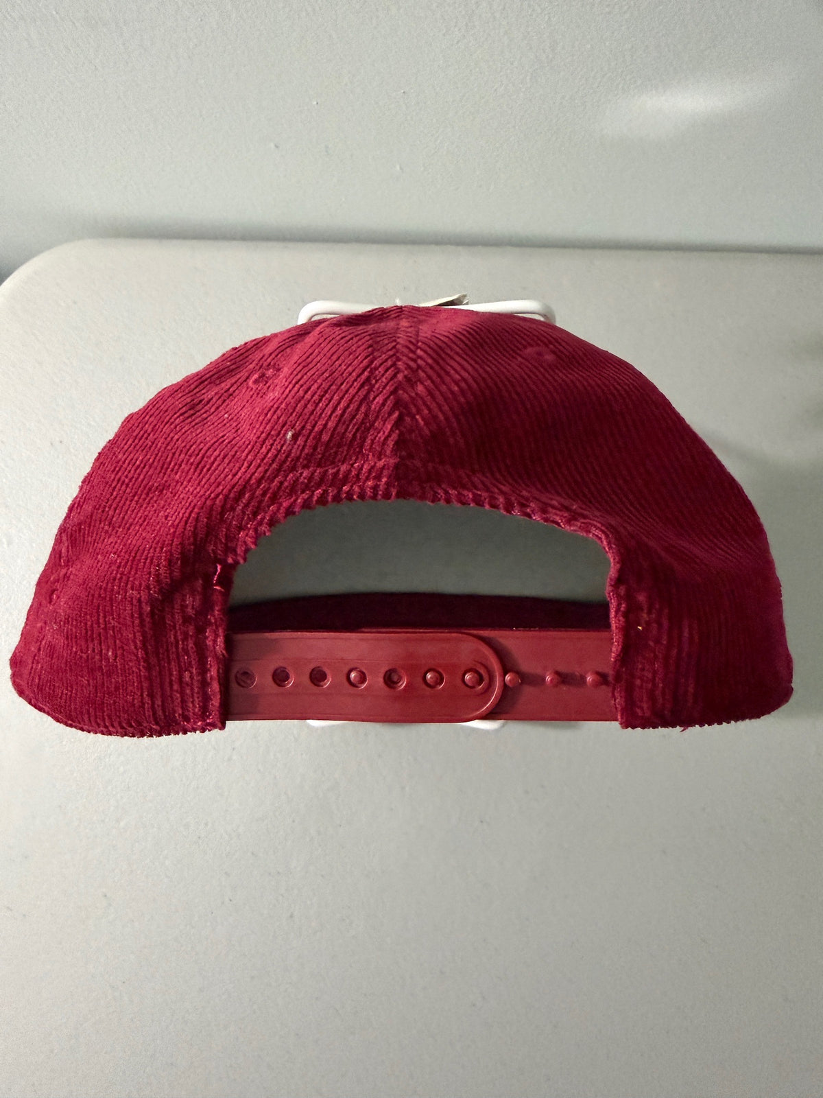Back View Closure: Brand new Coors Banquet Beer corduroy baseball hat featuring a deep maroon structured corduroy crown and brim, white embroidered classic script logo on the front panel, and an adjustable snapback closure from Bell's Bargain Barn.