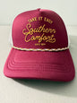 Brand new Southern Comfort Take It Easy mesh trucker hat featuring a structured maroon front foam panel, raised gold cursive lettering, white mesh back panels, a patterned front visor accent rope, and an adjustable snapback closre from Bell's Bargain Barn. 