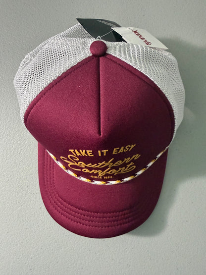 Top View: Brand new Southern Comfort Take It Easy mesh trucker hat featuring a structured maroon front foam panel, raised gold cursive lettering, white mesh back panels, a patterned front visor accent rope, and an adjustable snapback closre from Bell's Bargain Barn. 