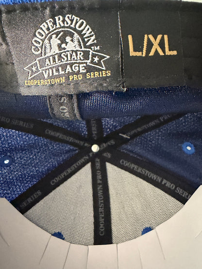 Branded Tag /Size View: Brand new royal blue Cooperstown All Star Pro Village Pro Series stretch fit baseball hat featuring an embroidered red and white tournament patch, a diamond-shaped L/XL silver visor sticker, and an athletic mesh-textured crown from Bell's Bargain Barn. 