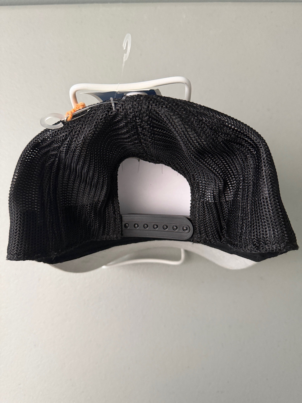 Back view: Brand new Harpoon Brewery Est. 198 mid crown fit trucker hat featuring a structured off-white front panel with a black embroidered logo patch, black mesh backing, a thin black visor rope, and a blue brim sticker from bell's Bargain Barn.