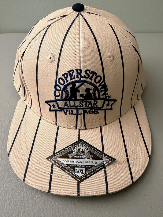 Brand new cream Cooperstown All Star Village Pro Series stretch fit baseball hat with navy blue pinstripes, featuring an embroidered navy tournament logo patch and a silver diamond-shaped L/XL visor sticker from Bell's Bargain Barn.  