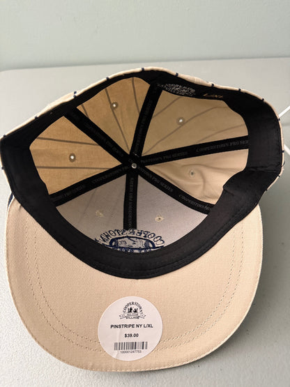 Inside View: Brand new cream Cooperstown All Star Village Pro Series stretch fit baseball hat with navy blue pinstripes, featuring an embroidered navy tournament logo patch and a silver diamond-shaped L/XL visor sticker from Bell's Bargain Barn.  