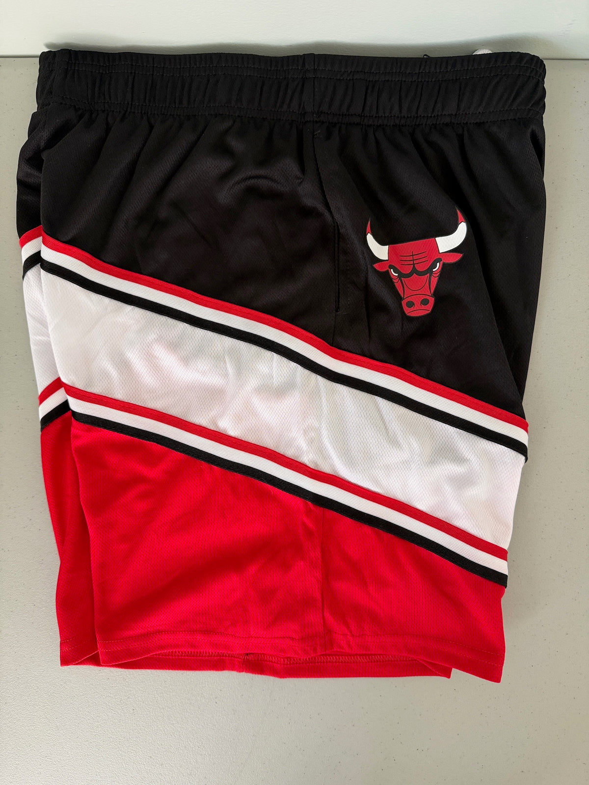 Screen-Printed Chicago Bulls charging bull logo on black mesh fabric.