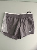 Front view of brand new Nike Women's 10K running shorts in grey with white mesh side panels and white Swoosh logo.