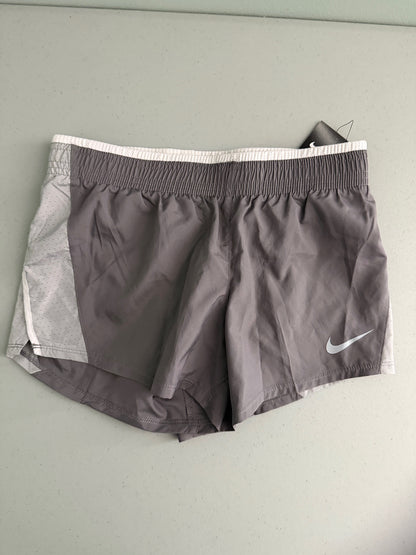 Front view of brand new Nike Women's 10K running shorts in grey with white mesh side panels and white Swoosh logo.