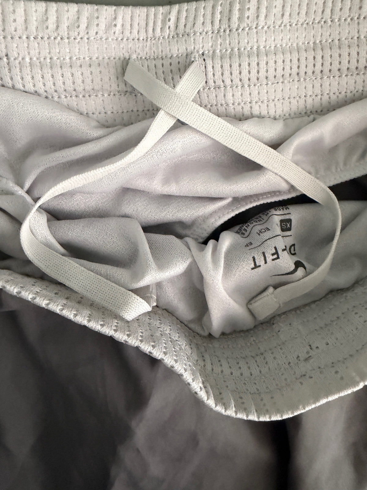 Interior view of the elastic waistband on Nike 10K shorts, highlighting the internal drawstring.