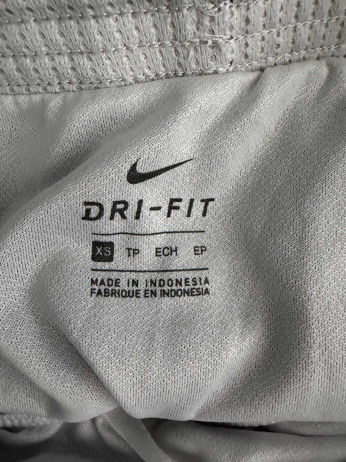 Clear view of the interior printed size label showing 'XS' and made in Indonesia.