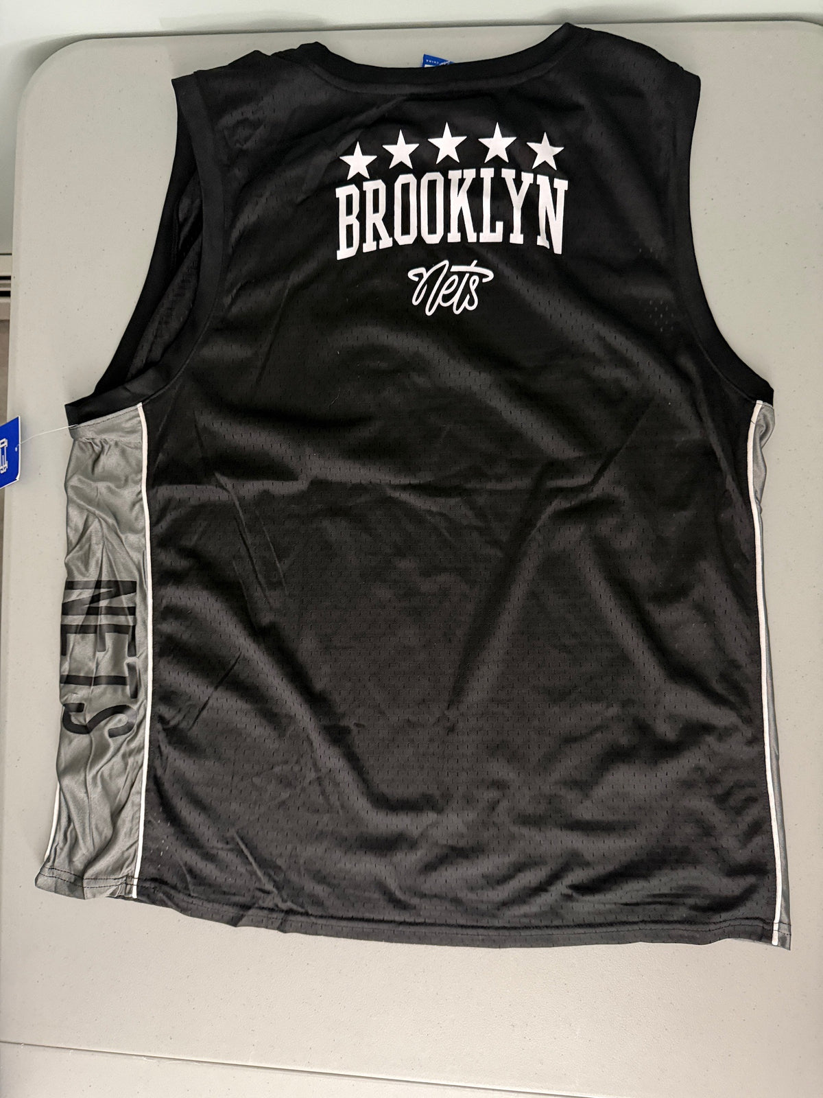 Back view of the Men's black Ultra Game NBA Brooklyn Nets mesh basketball tank top showing clean mesh fabric and team name graphics. 