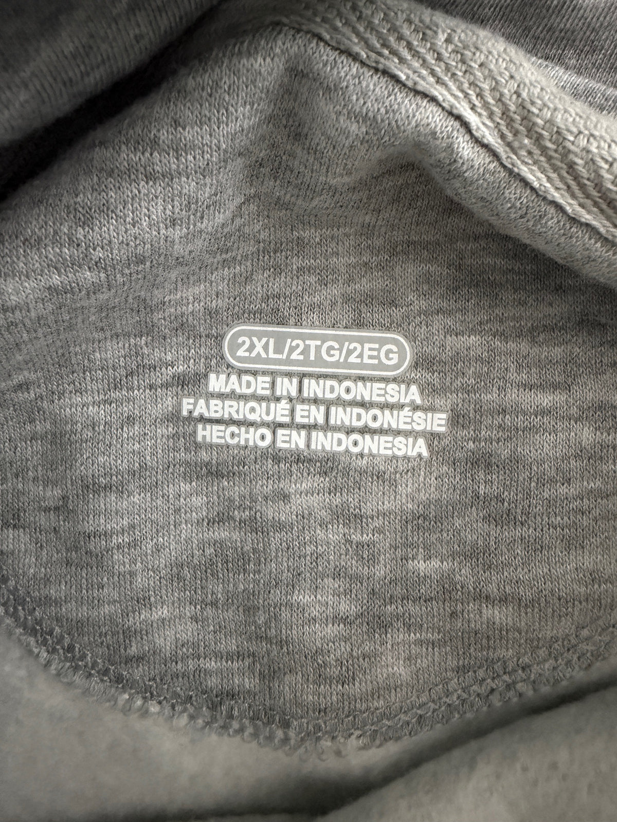 Size tag layout showing Men's 2XL/2TG/2REG on a gray NFL Champions hoodie. 
