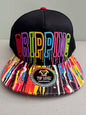 Front view of a black Top Level DRIPPING Snapback hat showcasing the bold, 3D raised rainbow-colored embroidered text and the multicolor paint splatter flat bill on a neutral bakground.