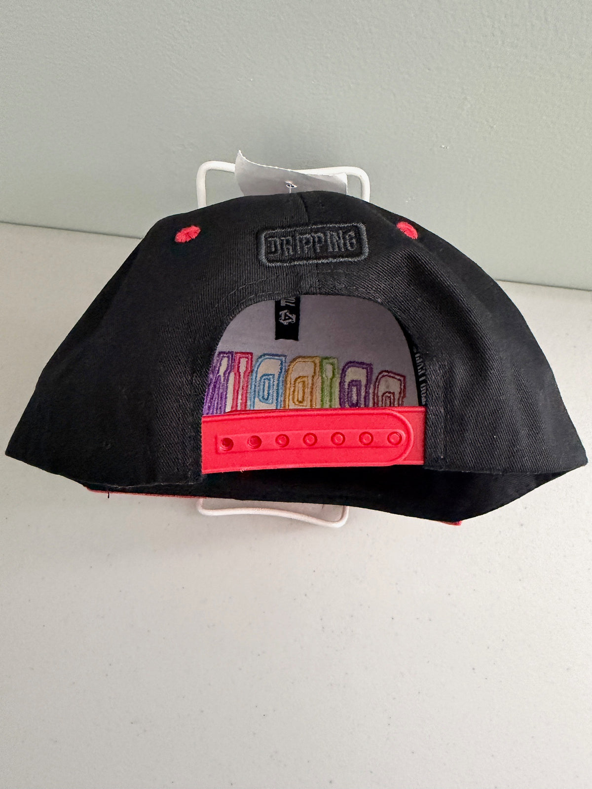 Back view of the black Top Level DRIPPING  baseball cap showing the adjustable plastic snapback closure and premium stitching, designed for an adjustable one-size-fits-most fit.